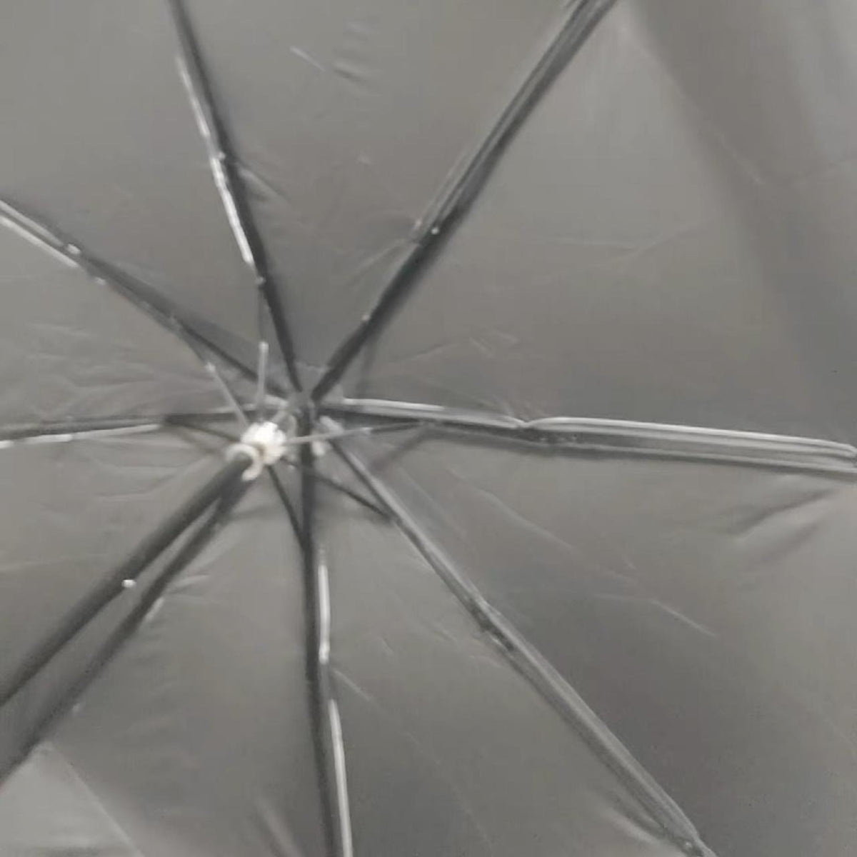 Underside of the Madoka Magica umbrella showing the black canopy and the eight frame ribs