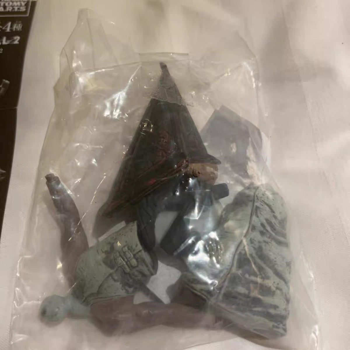 Pyramid-helm figure parts in sealed inner bag