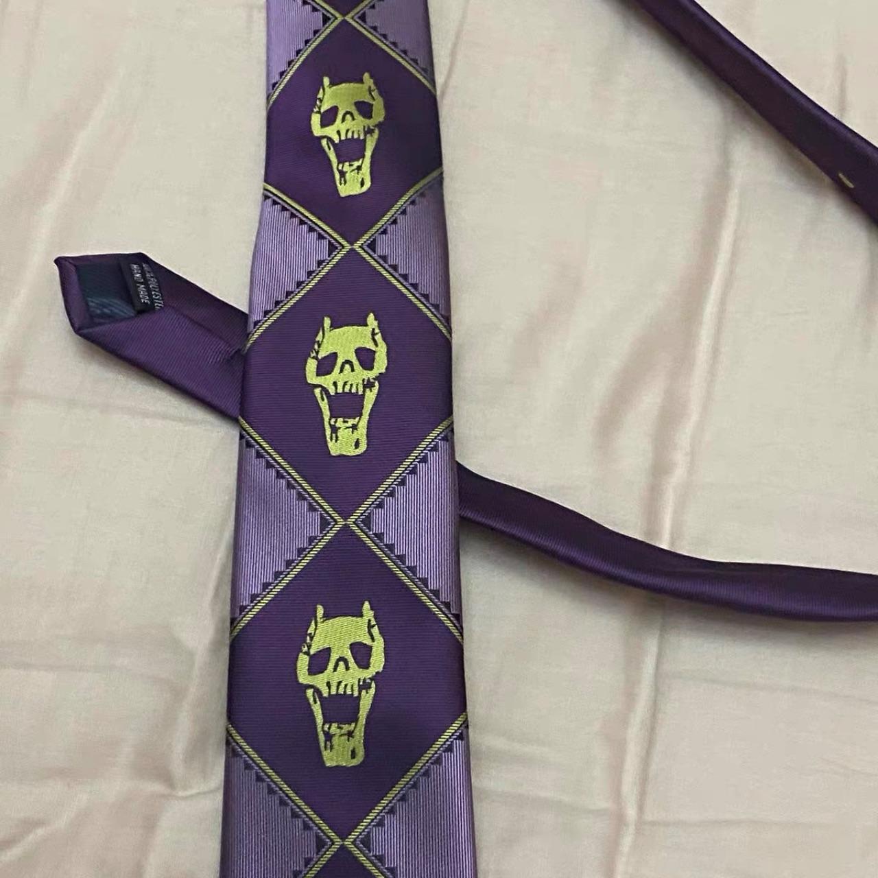 Yoshikage Kira tie flat-laid on linen, three skull motifs aligned along the blade