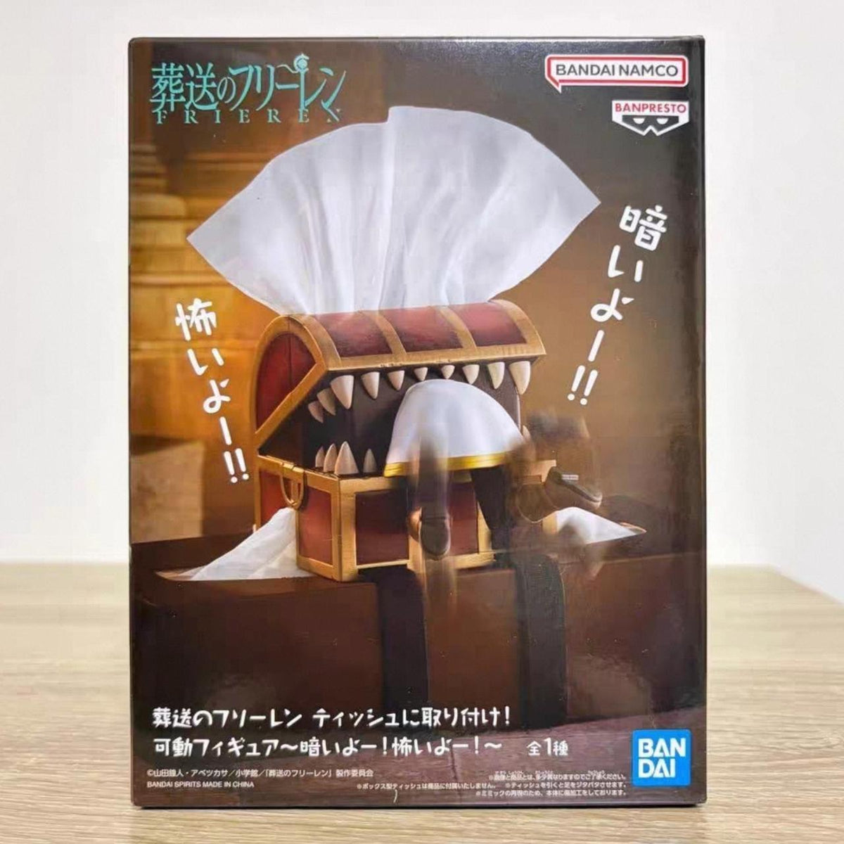 Frieren tissue box prize figure front of box — treasure chest with teeth clamped around a tissue, Frieren's white cloak underneath, Banpresto and Bandai Namco logos